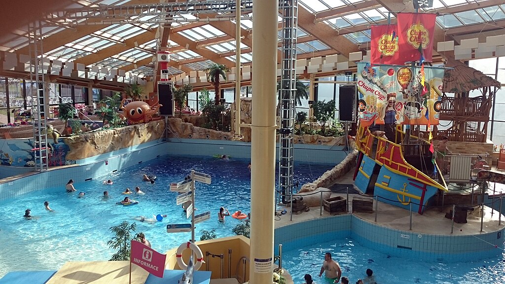 view of two large pools and a pirate ship themed play area at aquapalace praha, one of the best hotels for families in prgaue