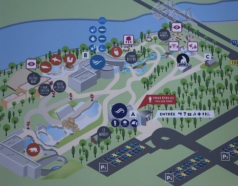 A colourful illustrated map of the Québec Aquarium shows labeled pathways, buildings, animal exhibits, and amenities, with a red marker indicating “Vous êtes ici” (You are here) near the main entrance. The layout includes icons for seals, polar bears, jellyfish, and more.
