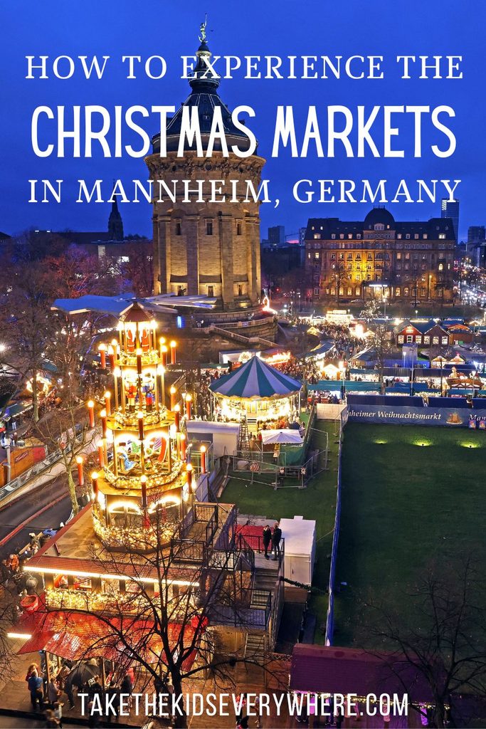 Pin image with text at top reading "How to experience the christmas markets in Mannheim" over a large photo of the market and brightly lit Christmas pyramid in front of the water tower. text at the bottom reads "takethekidseverywhere.com"