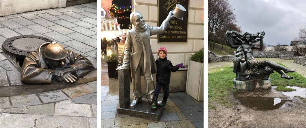 A trio of fun statues in Bratislava: on the left, a bronze figure nicknamed Čumil peeks out from a manhole cover in the sidewalk; in the center, a silver statue of Schöner Náci tips his top hat while a smiling child poses beside him; and on the right, a dramatic sculpture of a woman with flowing hair and a dolphin sits in a park, surrounded by puddles and winter trees.