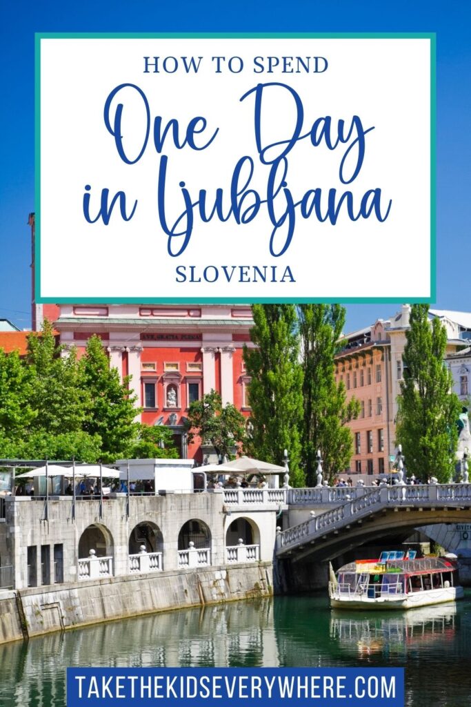 Scenic view of Ljubljana with pastel buildings, tall green trees, and a boat cruising along the Ljubljanica River beneath a stone bridge. Text overlay reads "HOW TO SPEND One Day in Ljubljana SLOVENIA" and "TAKETHEKIDSEVERYWHERE.COM"