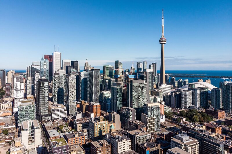 an aerial view showing skyscrapers rising from the streets of toronto with the CN tower standing tall over the city