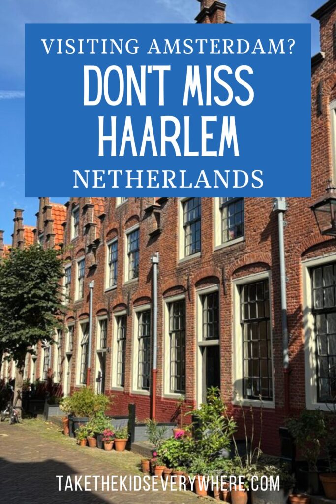 Red brick row houses with tall windows line a quiet street in Haarlem, Netherlands on a sunny day. Text overlay reads “Visiting Amsterdam. Don’t Miss Haarlem Netherlands” with “takethekidseverywhere.com” at the bottom.