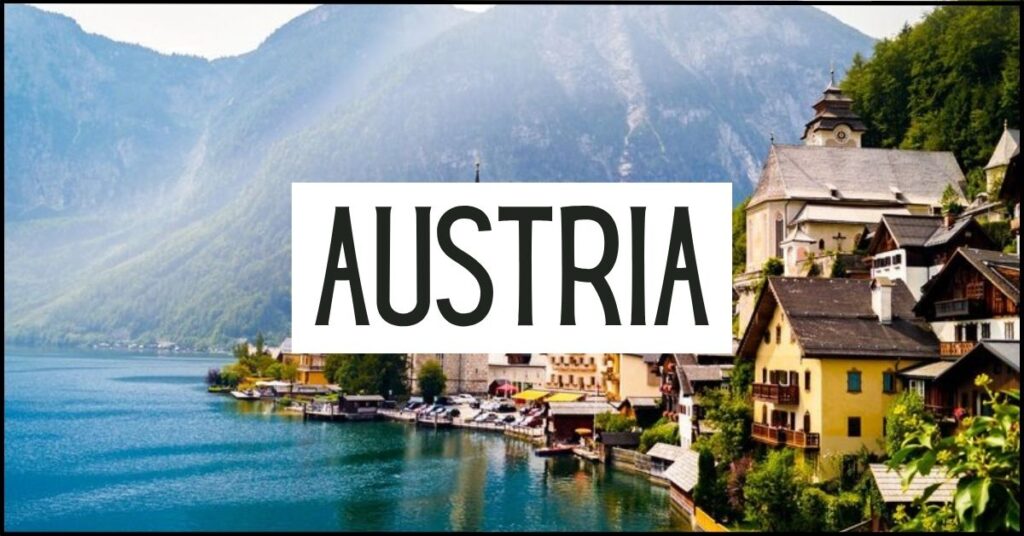 Hallstatt's lakeside village with colorful alpine houses and a church nestled beneath towering mountains beside a calm blue lake. Large white text overlay reads "AUSTRIA".